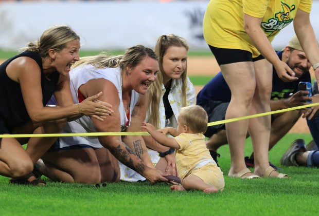 Parents cheer for their children to cross the finish line during a baby race in third inning of a game between the Savannah Bananas and Firefighters on Aug. 15, 2025, at Rate Field. (John J. Kim/Chicago Tribune)