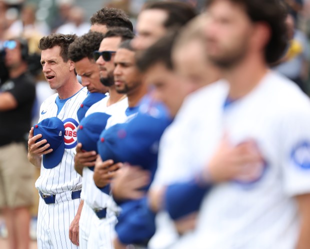 Chicago Cubs manager Craig Counsell (left) and his team stand for the national anthem before the start of game 1 of a double header against the Milwaukee Brewers at Wrigley Field in Chicago on Aug. 19, 2025. (Chris Sweda/Chicago Tribune)