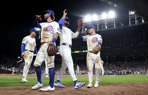 Chicago Cubs right fielder Willi Castro (second from right) is congratulated by his teammates after Castro threw out Milwaukee Brewers second baseman Brice Turang at home plate as Turang tried to score on a sacrifice fly in the seventh inning of Game 2 of a doubleheader at Wrigley Field in Chicago on Aug. 19, 2025. (Chris Sweda/Chicago Tribune)