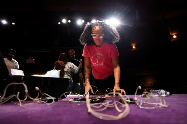 Production assistant apprentice Mariah Brown, 17, organizes microphones before distributing...
