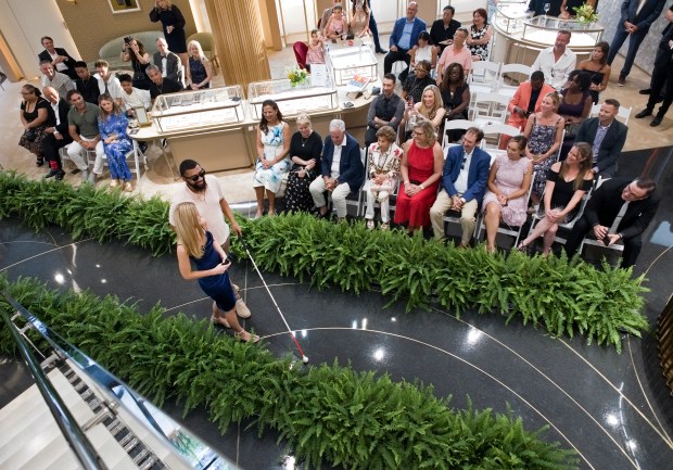 Volunteer Kate Visser and blind fashion model Jakar Robinson walk the the runway during the fashion show with visually impaired and blind models held at CD Peacock, Aug. 7, 2025, in Oak Brook. (James C. Svehla/for the Chicago Tribune)