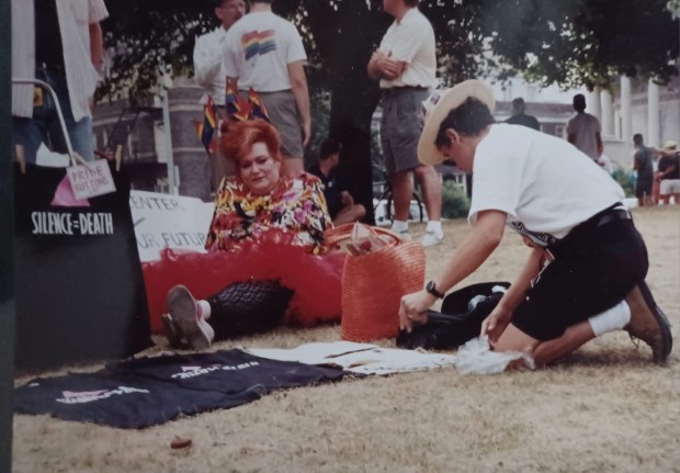 Danny Sotomayor (right) sets up his display of AIDS buttons and shirts as Lori Cannon watches on after the Chicago pride parade in 1991. (Pat Cummings)