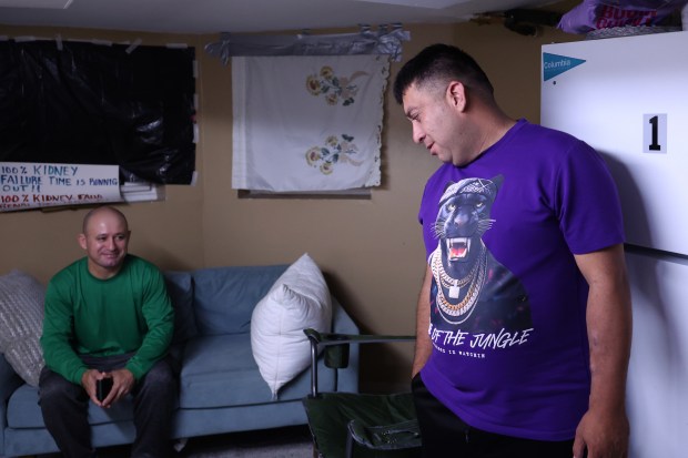 Venezuelan migrant brothers José Gregorio González, left, and Alfredo Pacheco talk as they wait at their basement apartment in Cicero before heading to UI Health University of Illinois Hospital for a kidney transplant, Aug. 14, 2025. (Antonio Perez/Chicago Tribune)