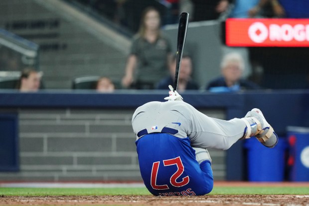 Chicago Cubs' Seiya Suzuki (27) rolls out of the way of an inside pitch against the Toronto Blue Jays during ninth inning MLB baseball action in Toronto on Tuesday, Aug. 12, 2025. (Nathan Denette/The Canadian Press via AP)