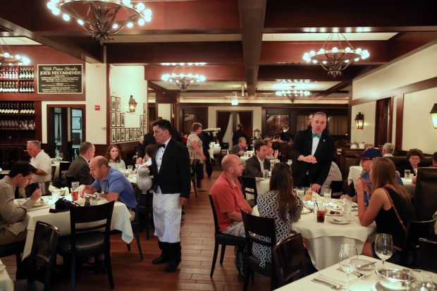 Joe's Seafood, Prime Steak & Stone Crab maitre d' Jim Herbert talks to customers during lunch in Chicago on Aug. 2, 2013. (Heather Charles/Chicago Tribune) 