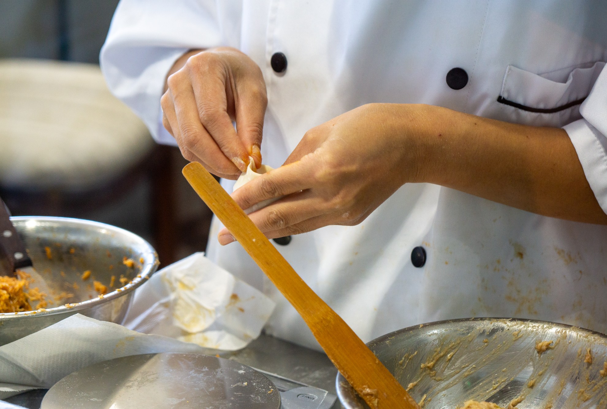 Hands folding dumpling at China Max Dumpling House