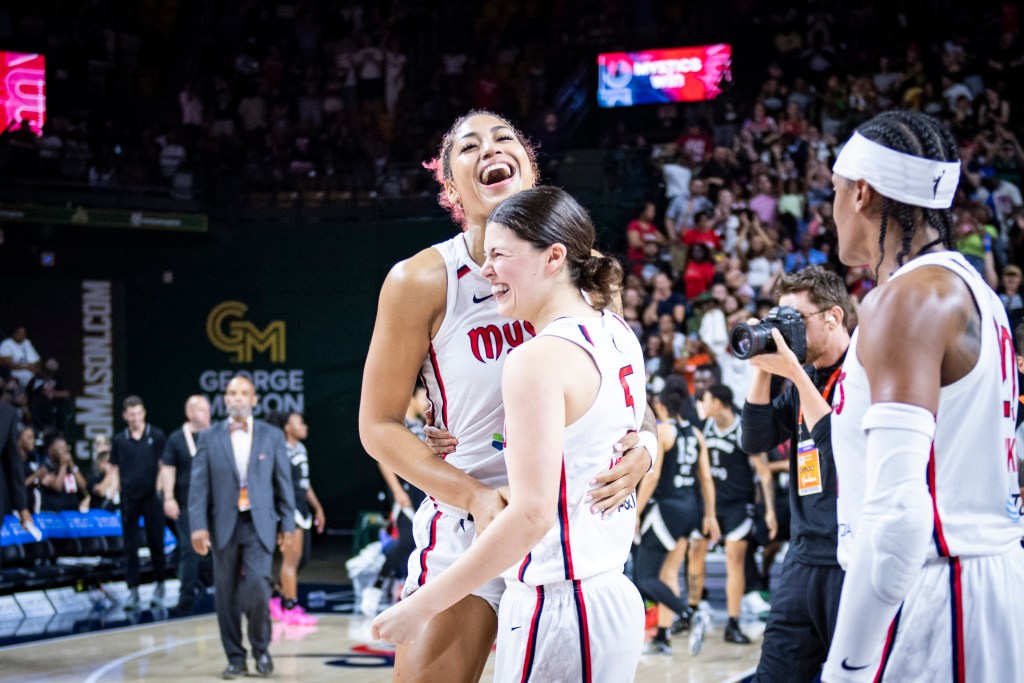 Washington Mystics center/forward Shakira Austin smiles and tilts her head up in celebration as she hugs guard Jade Melbourne after a win.