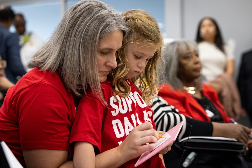 Sarah Evans holds daughter Anna and writes down a question about proposed library branch...