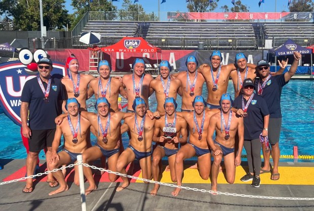 Coach Tommy Corcoran, Coach Heather Calvin, and Coach Spencer Rodman with the Del Mar Water Polo Club 18U team show their bronze medals and enthusiasm after the game to celebrate placing third in the national championship.Back row (l-r): Coach Tommy Corcoran, Oren Penning, Erik Kaszán, Colin McPhail, Kai Lewis, Ryan Fresca, Jett Taylor, Aidan Johnson, Coach Spencer Rodman; Front row (l-r): Hudson Tweed, Colton Bell, Maximus Arnold, Eamon Bruhn, Kenly Axline, Cameron Bench, Coach Heather Calvin (Photo by Grayson Taylor)
