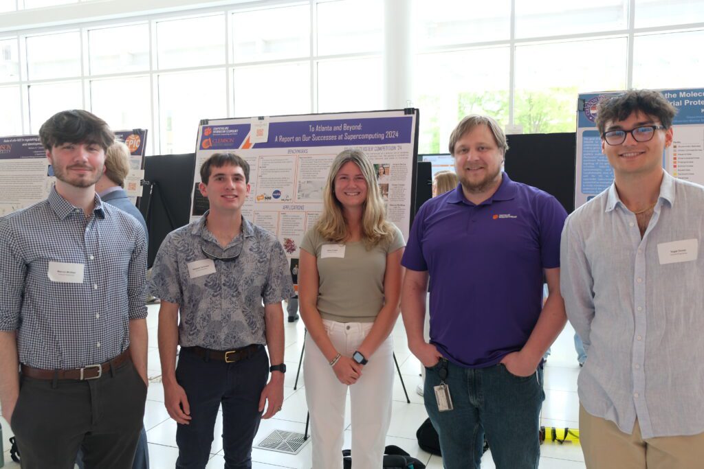 A group of students stand in front of their HPC poster in the Watt Family Innovation Center
