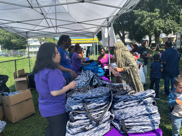 Bread of Life volunteers hand out 800 backpacks filled with school supplies at Sellers Park Saturday. (KATHLEEN E. CAREY - DAILY TIMES)