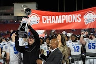 Memphis head coach Ryan Silverfield, left, lifts the Frisco Bowl trophy after an NCAA...