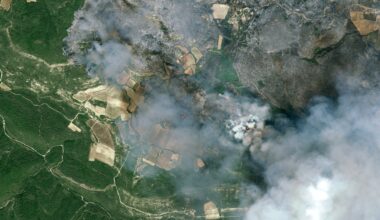 fire and smoke rolls through a green countryside as seen from space