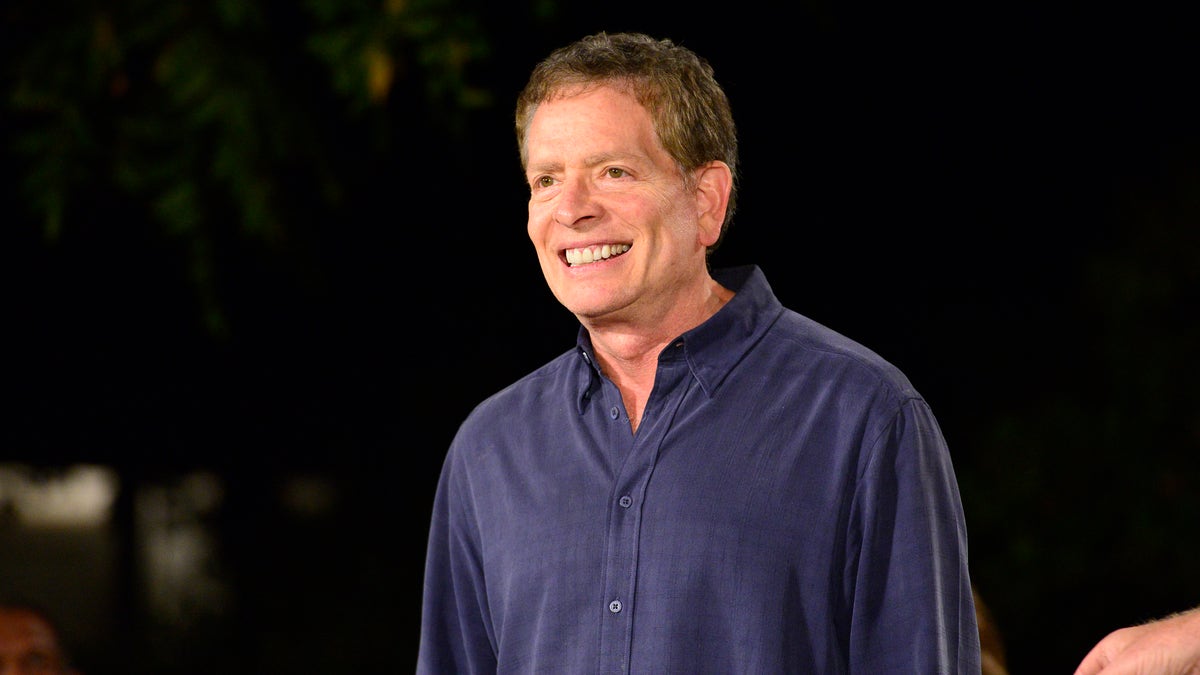 David Zucker smiles in a navy blue button down