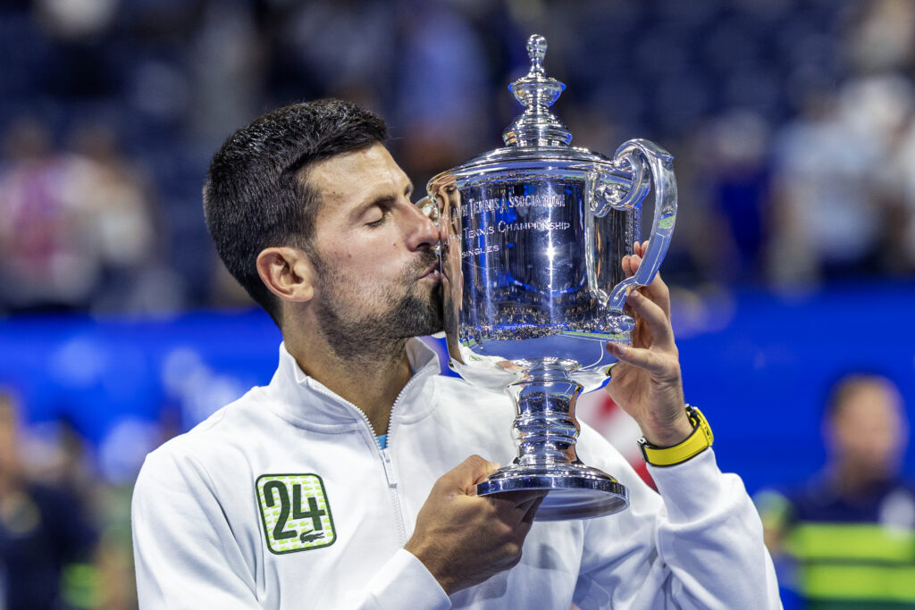 Novak Djokovic of Serbia with the winners' trophy and wearing a tracksuit representing his 24th grand slam win after his victory against Daniil Medvedev of Russia in the Men's Singles Final on Arthur Ashe Stadium during the US Open Tennis Championship 2023 at the USTA National Tennis Centre on September 10th, 2023 in Flushing, Queens, New York City.