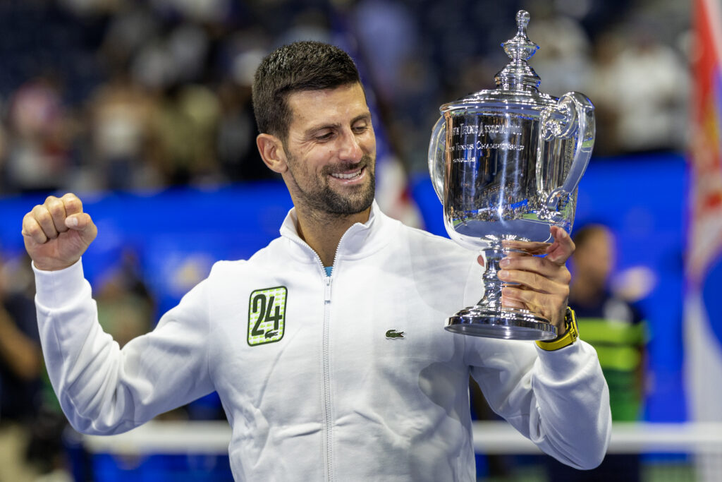 Novak Djokovic of Serbia with the winners' trophy and wearing a tracksuit representing his 24th grand slam win after his victory against Daniil Medvedev of Russia in the Men's Singles Final on Arthur Ashe Stadium during the US Open Tennis Championship 2023 at the USTA National Tennis Centre on September 10th, 2023 in Flushing, Queens, New York City.