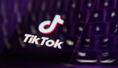 A laptop keyboard and TikTok logo displayed on a phone screen are seen in this multiple exposure illustration.