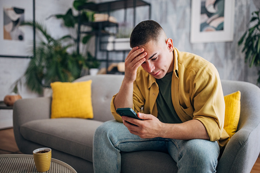 Stressed Man with smartphone and coffee cup