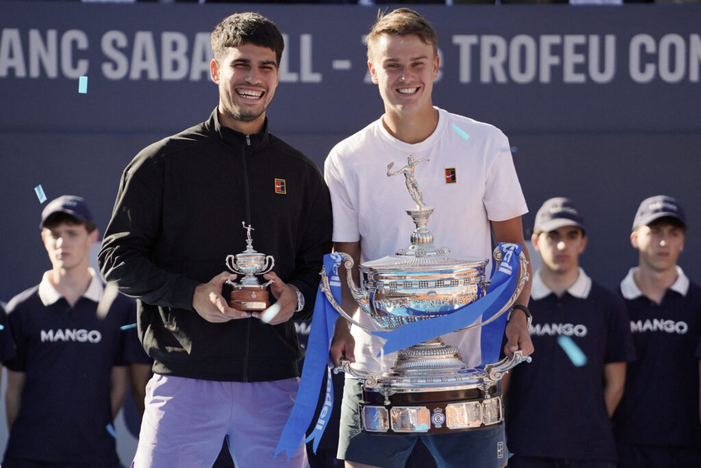 Denmark's Holger Rune (R) and Spain's Carlos Alcaraz hold up their trophies after the ATP Barcelona Open "Conde de Godo" tennis tournament singles final match at the Real Club de Tenis in Barcelona, on April 20, 2025. Rune won 7-6 6-2.