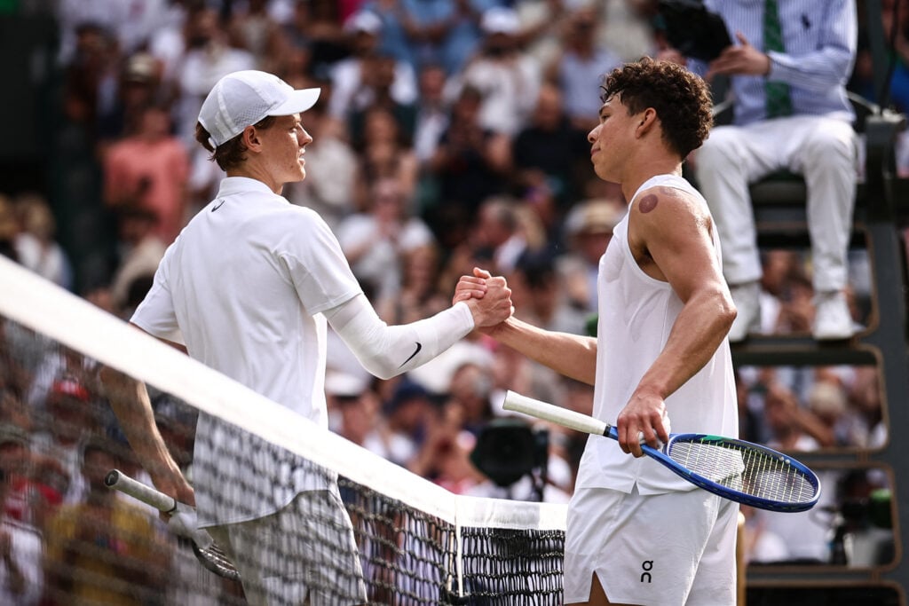 Jannik Sinner and Ben Shelton shake hands at the net after their match at Wimbledon in 2025