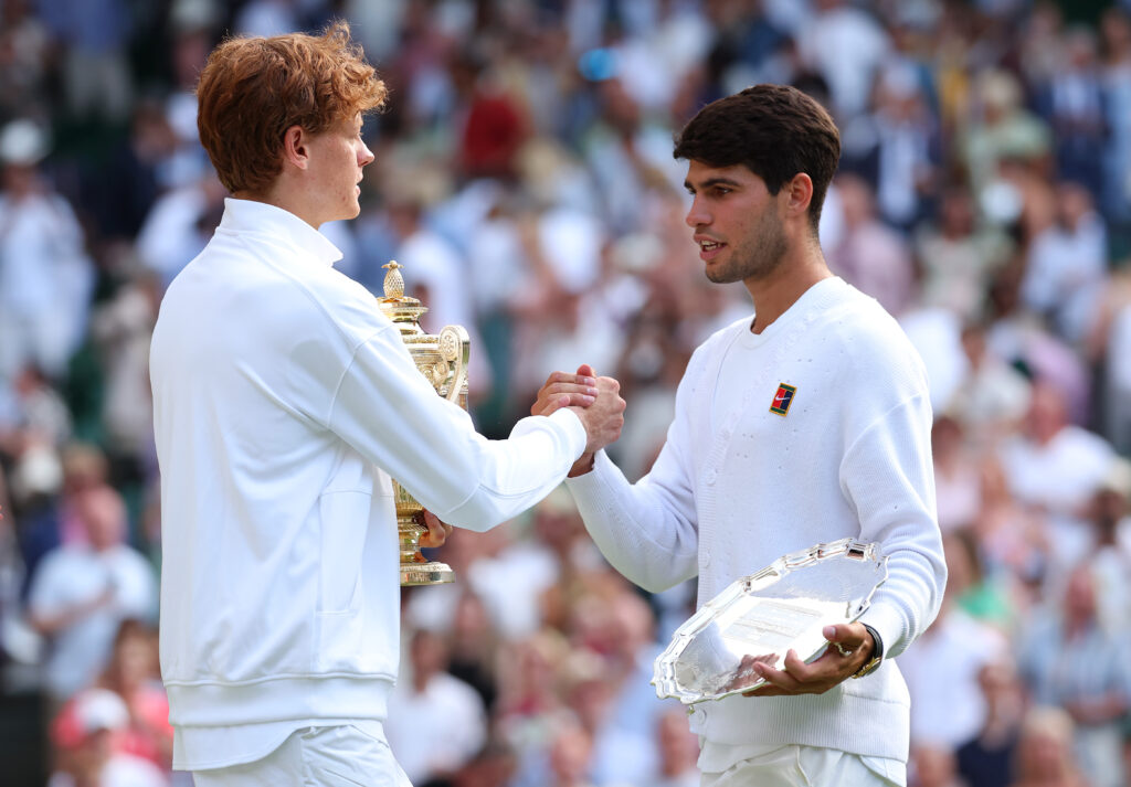 Jannik Sinner of Italy with the Gentlemen’s Singles Trophy greets Carlos Alcaraz of Spain with the Gentlemen’s Singles Runner-Up Trophy after the Gentlemen’s Singles Final on day fourteen of The Championships Wimbledon 2025 at All England Lawn Tennis and Croquet Club on July 13, 2025 in London, England.