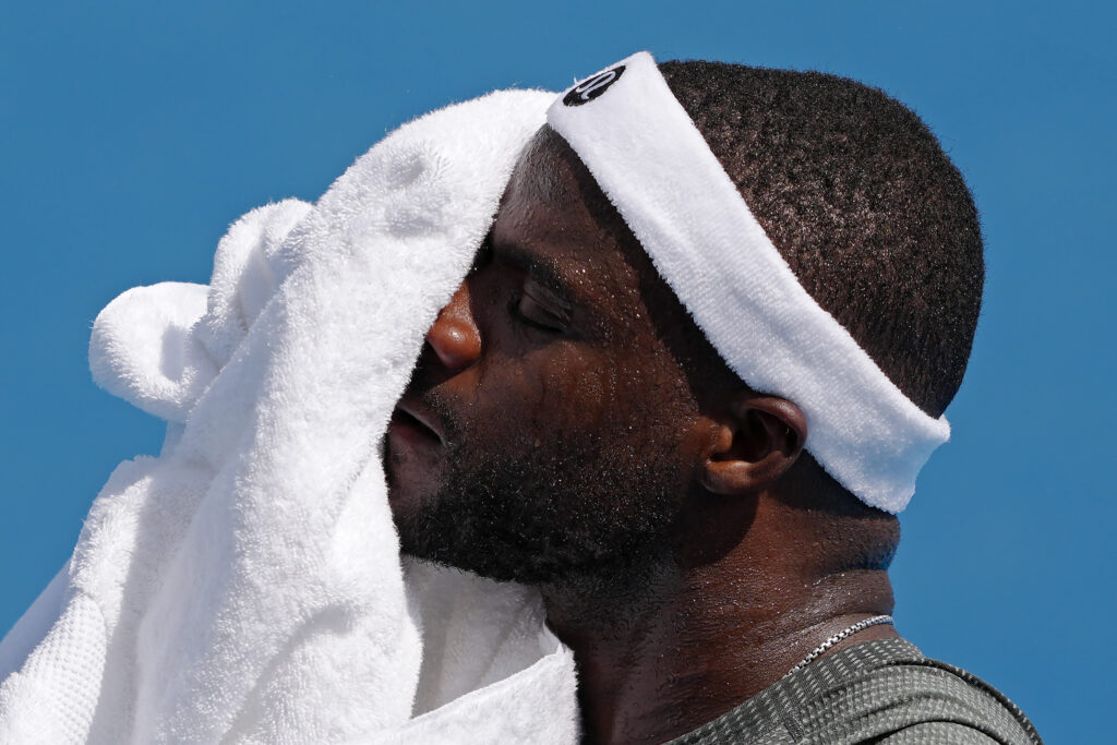 Frances Tiafoe wipes his face with a towel