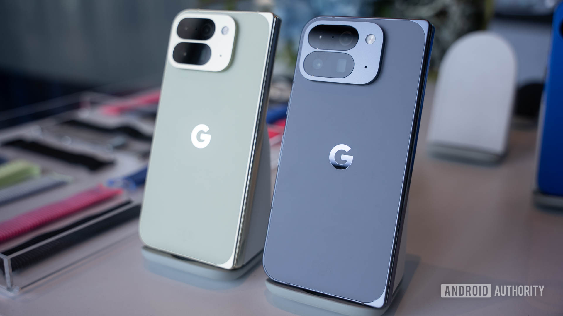Google Pixel 10 Pro Fold in Jade next to Google Pixel 10 Pro Fold in Moonstone on stands