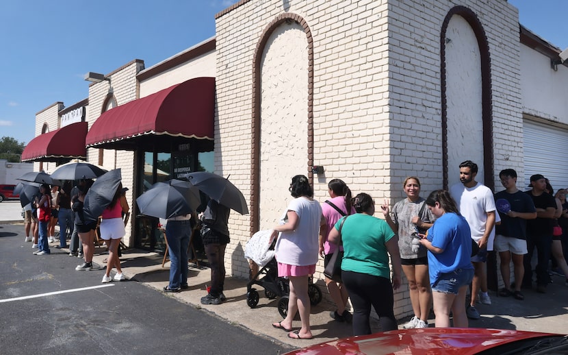 A long line of customers brave the summer heat for the opportunity to purchase their...