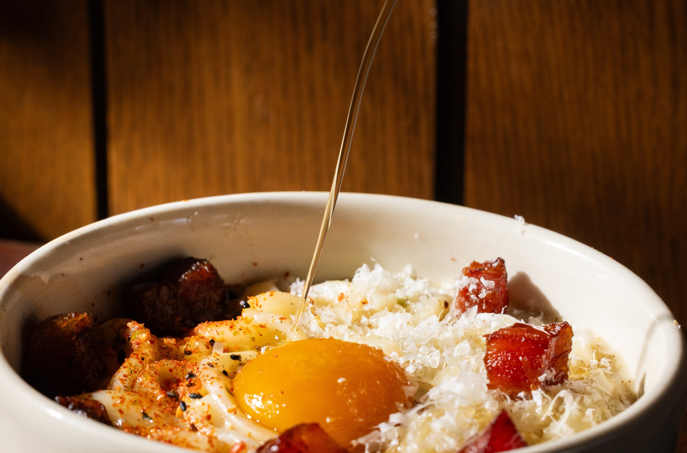 Oil is shot into a bowl of udon carbonara.