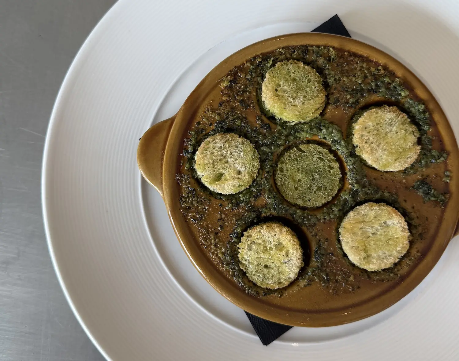 Food from San Diego restaurant  Bistro Du Marché in La Jolla featuring their Escargots De Bourgogne, Beurre D’ail & Herbes Potagères