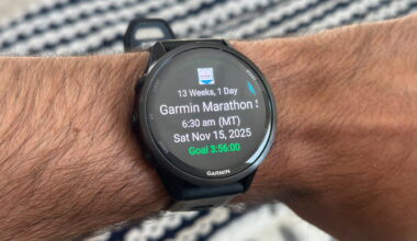 The Garmin Forerunner 970 on the author's wrist, showing the Primary Race widget with the Garmin Tucson Marathon time, date, weeks until the event, and goal time.
