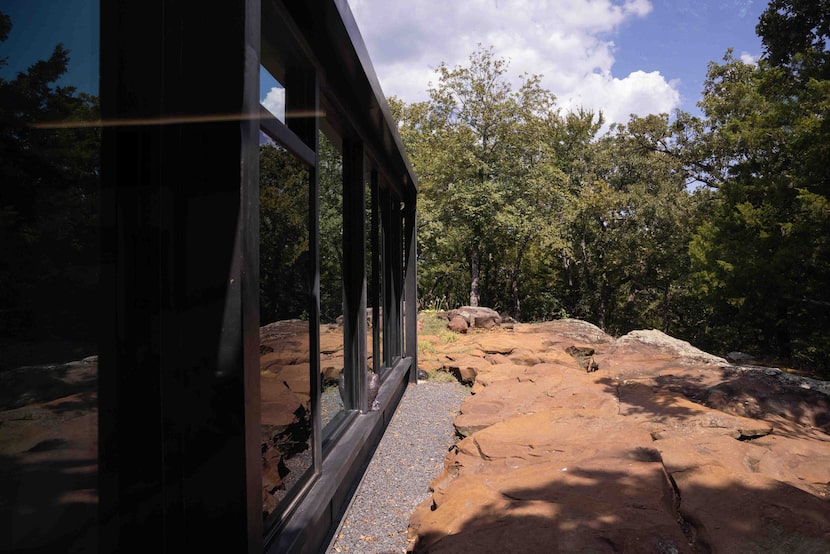 The "Recycled Glass House" abuts sandstone outcropping. 
