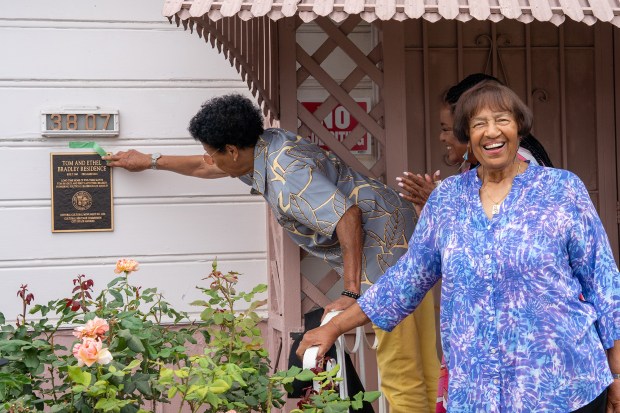 Toney Bradley, left, unveils a plaque honoring the former residence...