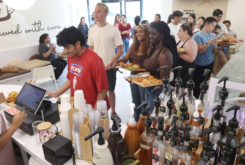 Customers wait in a long line to purchase items at the highly popular Pan Pan bakery,...