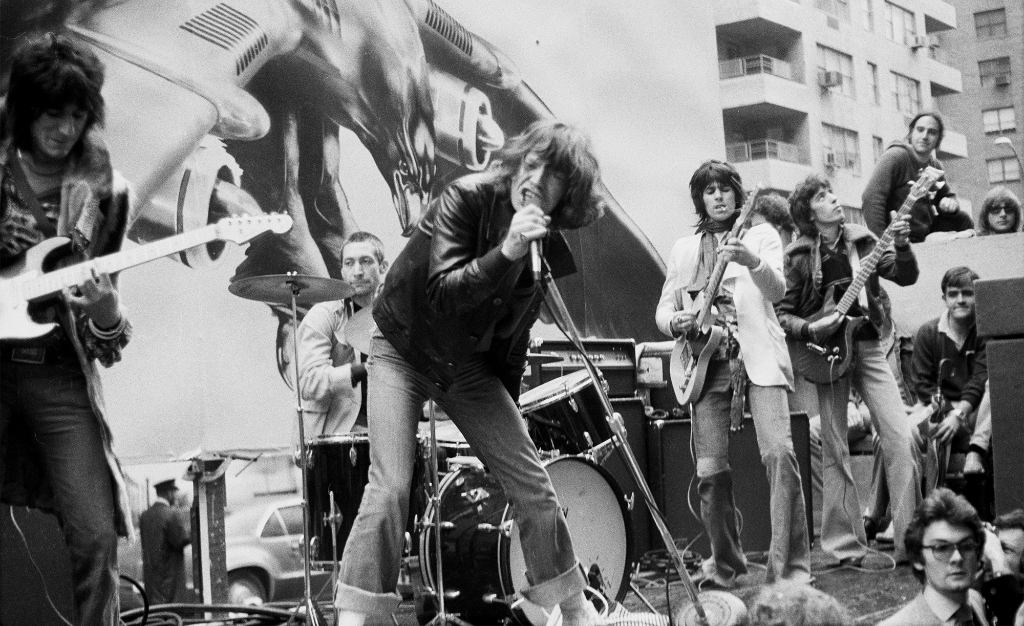 British guitarist and songwriter Ronnie Wood, British drummer Charlie Watts, British singer-songwriter Mick Jagger, British guitarist and songwriter Keith Richards, and British songwriter and bass player Bill Wyman as British rock band The Rolling Stones perform on the back of a flatbed truck passing along Fifth Avenue in New York City, New York, 1st May 1975. The stunt, which saw the band play 'Brown Sugar', was to announce their 'Tour of the Americas '75' tour.