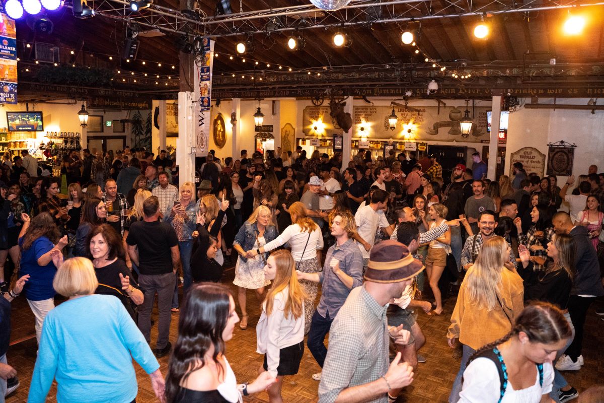 People dance in the biergarten at Old World Huntington Beach