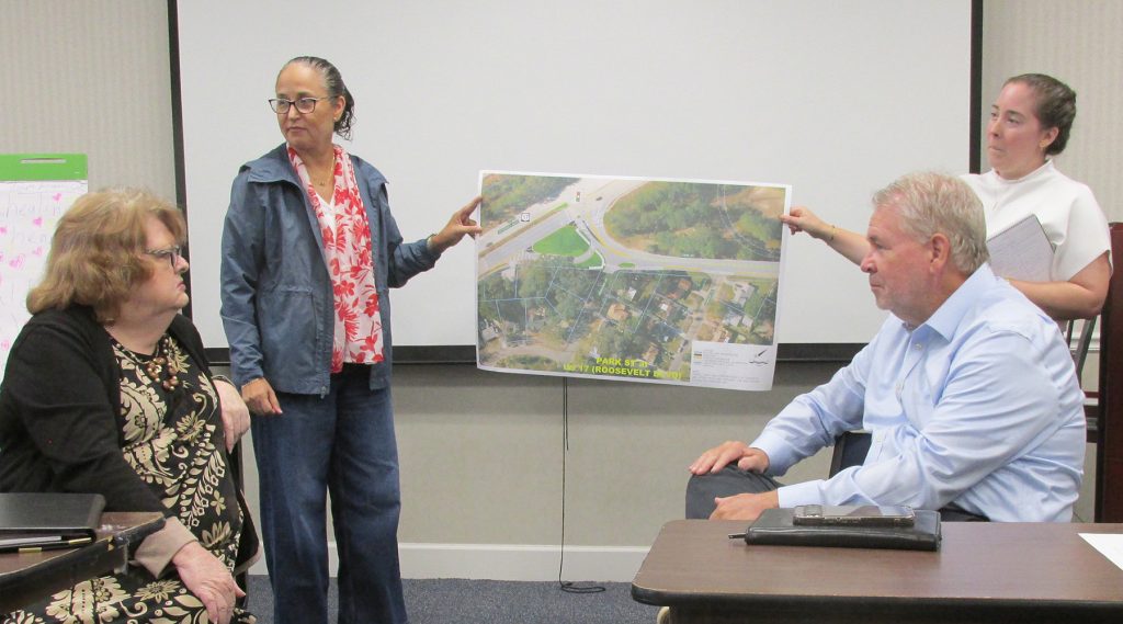 Corinne Grant and Brooks Dame hold a section of a diagram for the proposed road project that will add a roundabout to the intersection of Park Street and Blanding Boulevard.