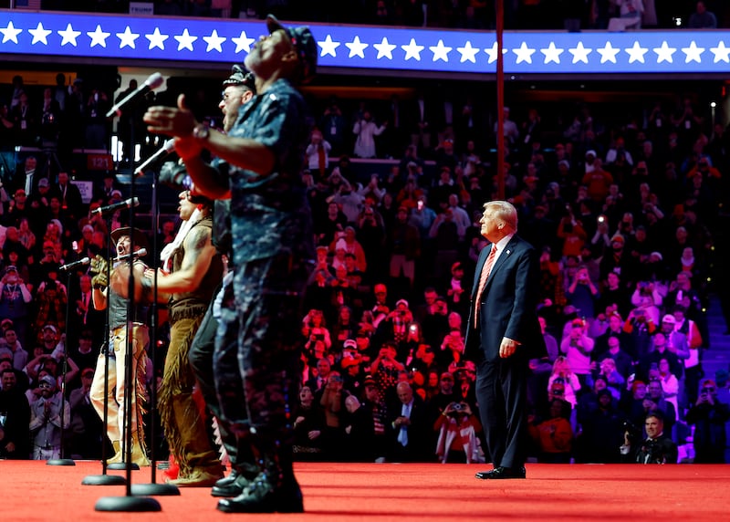 President Donald Trump watches on stage while the Village People perform "YMCA" on stage at his victory rally at the Capital One Arena on January 19, 2025 in Washington, D.C.