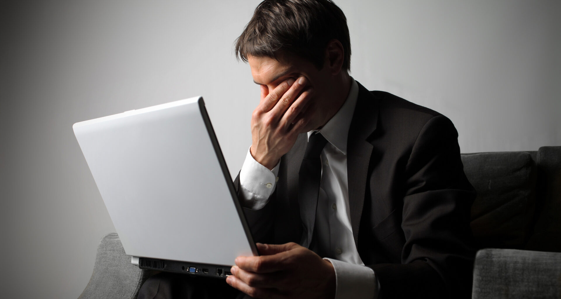 Frustrated looking person sat at their Windows 10 laptop