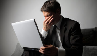 Frustrated looking person sat at their Windows 10 laptop