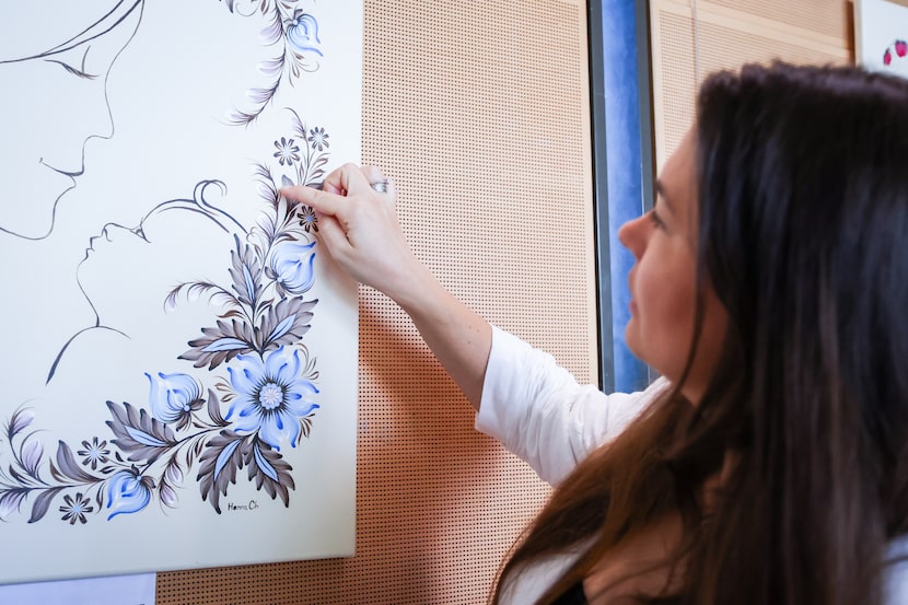 Ukrainian refugee Hanna Chekodanova points out details in her Petrykivka art Wednesday, Aug....
