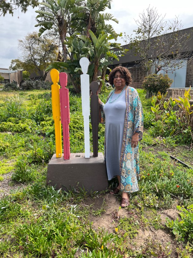 Carole Wade Boyce stands next to the weathered statue her father, Rossie Wade, created at the San Diego College of Continuing Education's Educational Cultural Complex back in the 1970s. (Courtesy of Carole Wade Boyce)