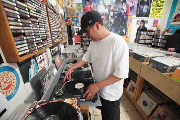 Ricky Regretti plays at the turntable, also known as vinyl record player, at Beat Box Records in Barrio Logan on Friday, Aug. 15, 2025. (Michael Ho / The San Diego Union-Tribune)