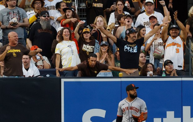 Heliot Ramos #17 of the San Francisco Giants looks on as fans celebrate a home run, that was eventually overturned because of fan interference hit by Xander Bogaerts #2 of the San Diego Padres at Petco Park on Aug. 18, 2025 in San Diego, California. (K.C. Alfred / The San Diego Union-Tribune)