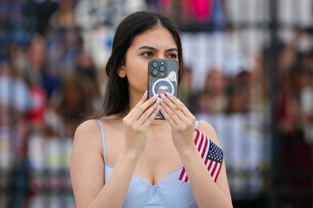 Caitlin Dizon of Mission Valley used her phone to videotape as the USS Carl Vinson pulled up to the pier.  Kennth Davis is assigned to the Carl Vinson and is among the sailors on board the USS Carl Vinson who are returning from deployment to their homeport at Naval Air Station North Island on Thursday, Aug. 14, 2025, in Coronado, CA. (Nelvin C. Cepeda / The San Diego Union-Tribune)