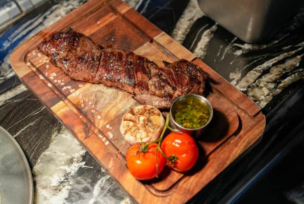 Entraña served with garlic and tomatoes at Piedra Santa. (Alejandro...