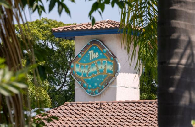 A sign for the Wave Waterpark is displayed on the tower that's above its main building. (Charlie Neuman / For The San Diego Union-Tribune)