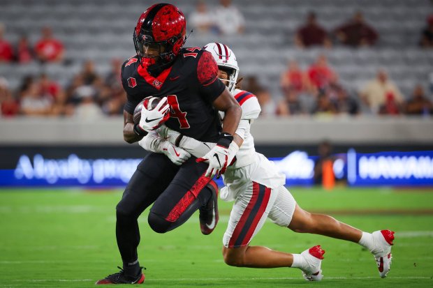 Mikey Welsh #14 of San Diego State is tackled by Cam Johnson #16 of Stony Brook during the first half at Snapdragon Stadium on Thursday, Aug. 28, 2025 in San Diego, CA. (Meg McLaughlin / The San Diego Union-Tribune)