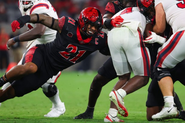 Tano Letuli #21 of the San Diego State Aztecs tackles Roland Dempster #4 of the Stony Brook Seawolves during the second half at Snapdragon Stadium on Thursday, Aug. 28, 2025 in San Diego, CA. (Meg McLaughlin / The San Diego Union-Tribune)