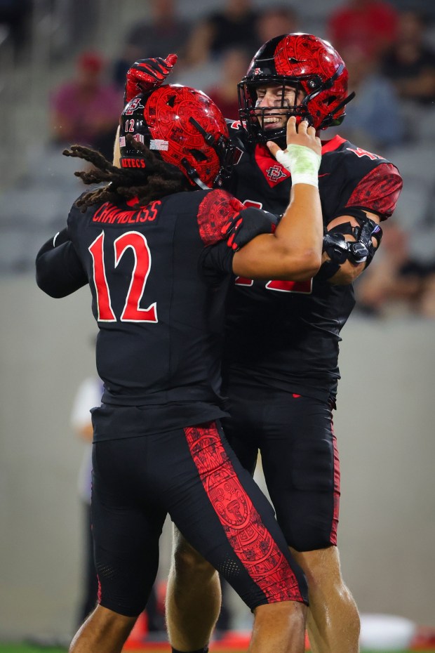 Owen Chambliss #12 and Brady Anderson #42 of the San Diego State Aztecs celebrate after Anderson's touchdown against the Stony Brook Seawolves during the second half at Snapdragon Stadium on Thursday, Aug. 28, 2025 in San Diego, CA. (Meg McLaughlin / The San Diego Union-Tribune)